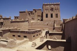 Image du Maroc Professionnelle de  La Kasbah de Taourirt fut édifiée au 17ème siècle par la tribu des Glaoui, située sur une colline au centre urbain de la ville d'Ouarzazate, cette remarquable ancienne bâtisse en pisé parfaitement conservée est l'une des plus belles constructions architecturales de la ville. La Kasbah qui ressemble à un grand château de sable incrusté dans le désert, fait partie du circuit touristique, elle a été classé Patrimoine Mondiale de l’Unesco. Ce véritable joyau de Ouarzazate permet au visiteur de découvrir l’intérieur d’une ksar où résident souvent la population berbères du sud du Maroc. Photo datant du Samedi 23 Août 1997. (Photo / Abdeljalil Bounhar) 